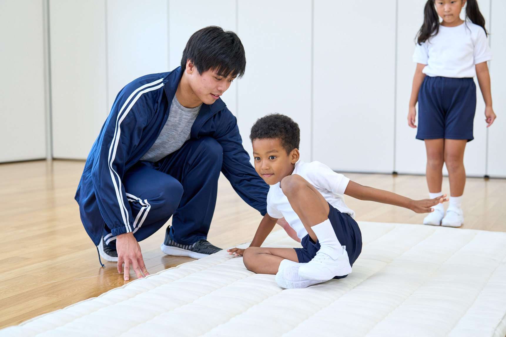 A Young Boy Practicing Gymnastics with Guidance